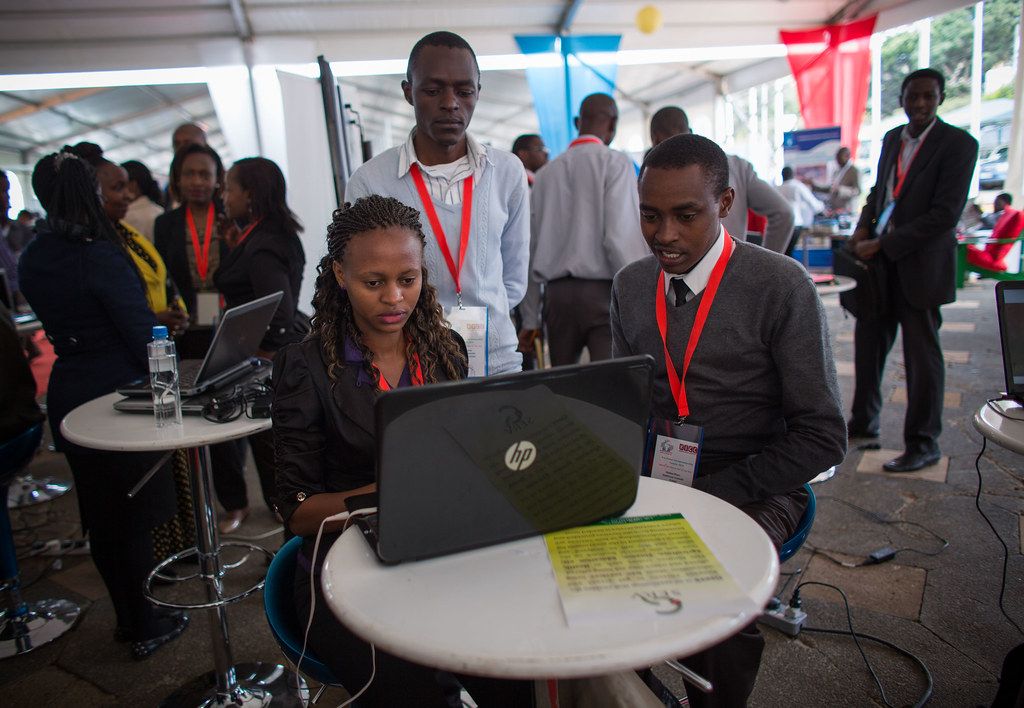 Young people working on a laptop at a technology expo in Africa