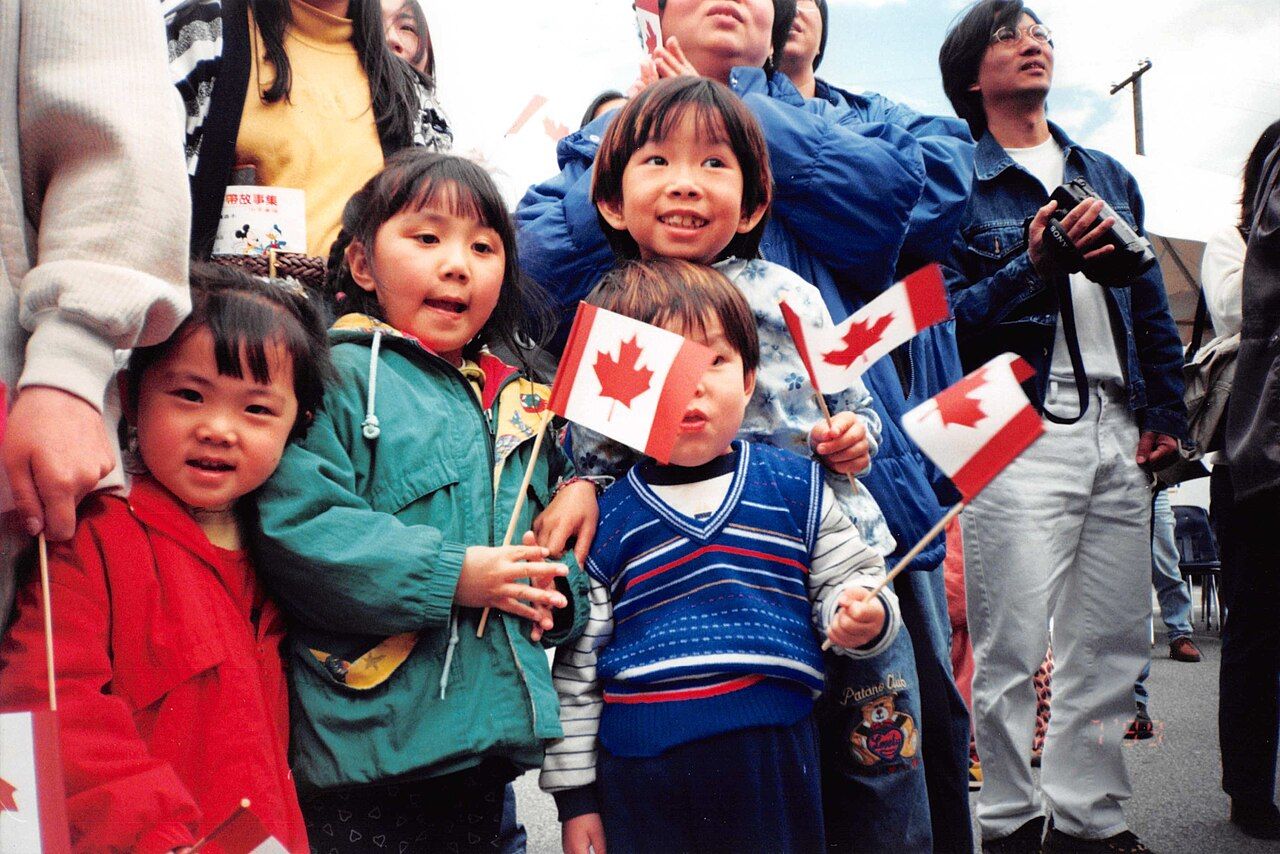 Young children waving Canadian flags